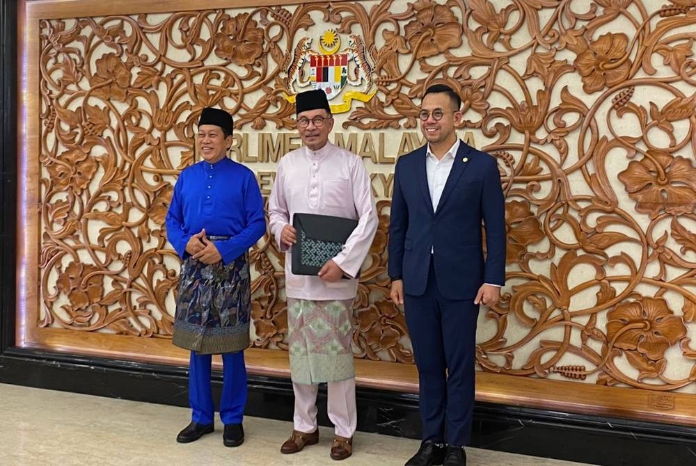 Belanjawan 2024: Anwar segak berbaju Melayu ungu, membawa beg buatan pengusaha batik Kelantan